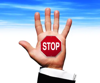 a photo image of a business man's hand with a stop sign
