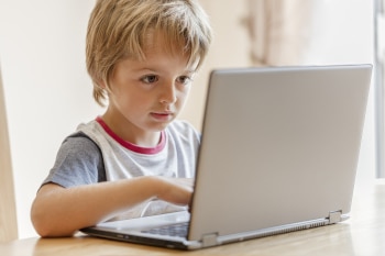 Young boy working on laptop computer