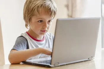 Young boy working on laptop computer