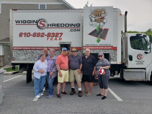 A group of residents standing in front of the Wiggins Shredding Truck Posing for the picture