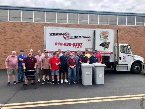 A group of residents standing in front of the Wiggins Shredding Truck Posing for the picture