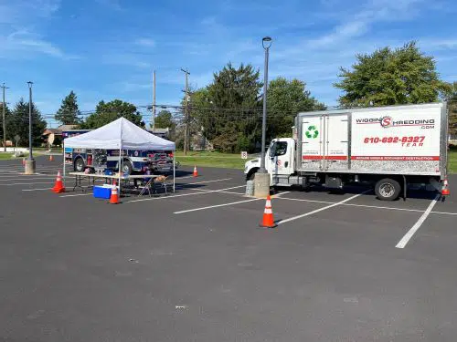 A Wiggins Shredding Truck Parked in a parking lot with a Tent and Pylons ready for a shred event
