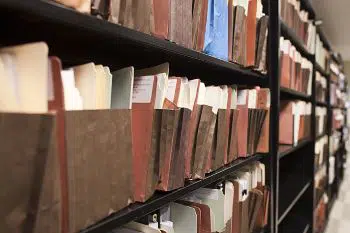 A long row of office shelving filled with expandable folders containing documents