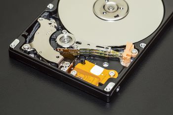 Photo of an open case hard disk drive sitting on a black surface.